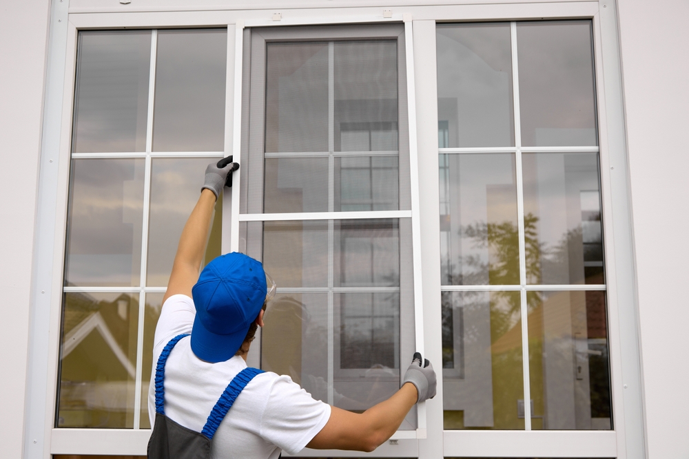 A man in full uniform is installing a window